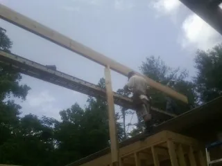 Carpenter setting a ridge beam over a new addition frame — Ice Dam Removal by Roofing Brothers in Black Hawk