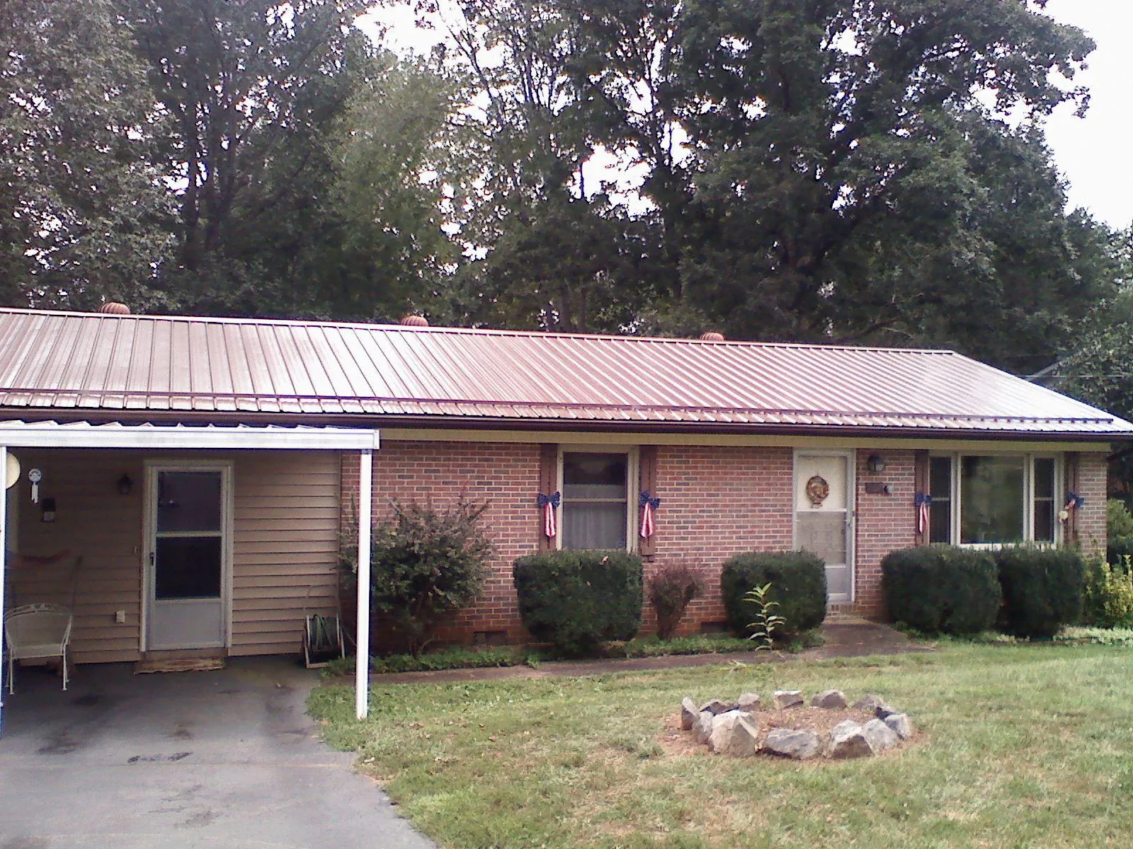 Bronze metal roof and carport on a brick ranch home — Roof Repair work by our crew in Black Hawk
