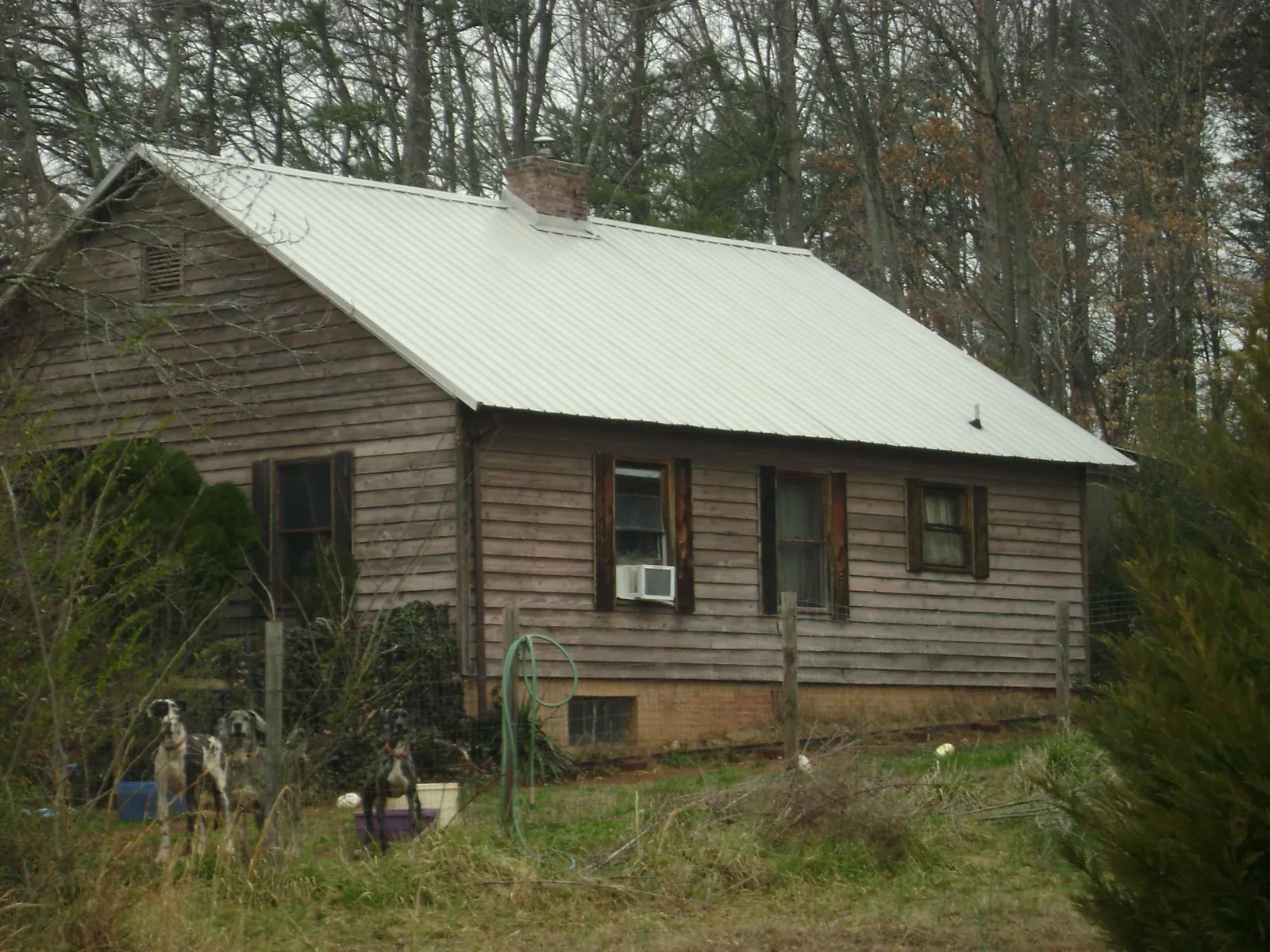 White metal roof on an old wood sided farmhouse, from a Metal Roof Installation job in Black Hawk